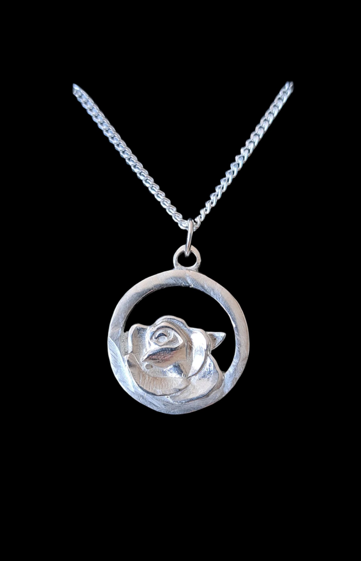 Silver rose pendant necklace on a black background